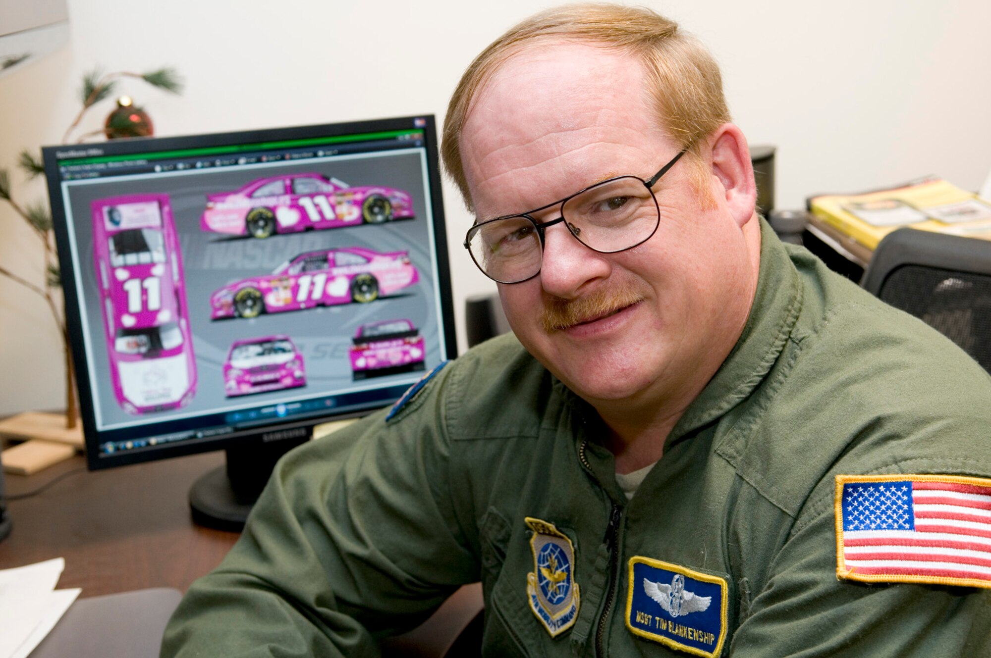 Master Sgt. Tim Blankenship sits in front of a computer monitor displaying  his award-winning signature design for Toyota’s Sponsafier 3 contest. Blankenship submitted the design to help generate awareness for Lafora Disease. (National Guard photo by Master Sgt. Emily Beightol-Deyerle)