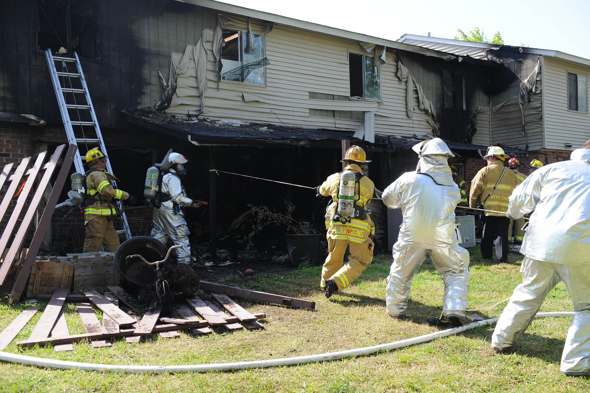 Firefighters from the 633rd Civil Engineer Squadron and Yorktown Fire Department test the structural stability of a building after a fire in base housing in April 2010. The fire caused more than $100,000 damage and displaced three families. (U.S. Air Force photo by Airman Rebecca Montez/Released)