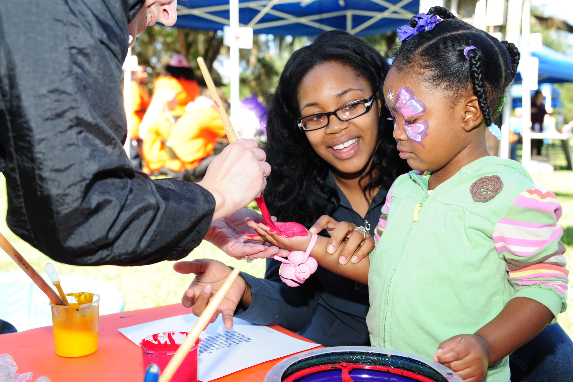 Garynn Napiter, gets her hands painted for decorative art project with help from her mother Blasia, at the Child Find/Exceptional Family Member Program Extravaganza ?Special Needs Fair? Oct. 1  at Marrington Plantation, Joint Base Charleston-Weapons Station.The fair is designed to help families with children who have special needs by providing entertainment while  keeping them aware of the resources available on and off base. The extravaganza  featured fun, food, games, prizes and music provided by more than 20 local resources agencies. Garynn is the daughter of Blasia and Navy E-3 Fireman, assigned to NNPTC. (U.S. Air Force photo/Tech. Sgt Chrissy Best) 

