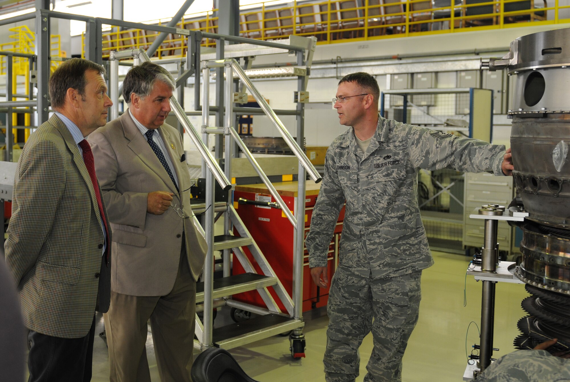ROYAL AIR FORCE LAKENHEATH, England - Tech Sgt. Timothy Johnson (right), 48th Component Maintenance Squadron modular dock chief, explains the work being done on a Pratt and Whitney F100-229 Core Module to the High Sheriff of Suffolk Steven Miles and High Sheriff of Cambridgeshire Richard Barnwell during a base visit, Oct. 3, 2011.  The High Sheriffs of Norfolk, Suffolk, and Cambridgeshire and their spouses took a tour of the propulsion shop, air traffic control tower, Hangar 7 and the child development center to continue to build partnership capacities with local community leaders.  (U.S. Air Force photo by Airman Cory D. Payne)