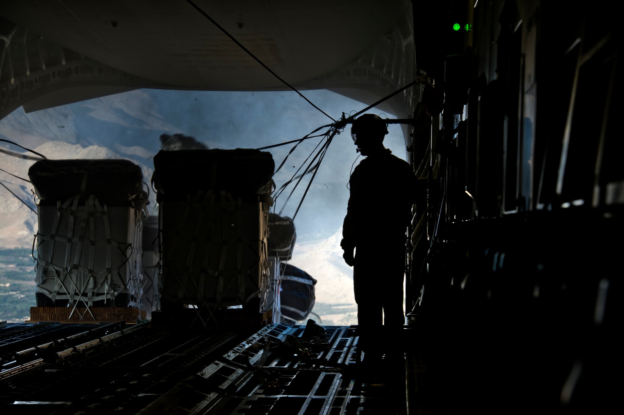 A member of the 816th Expeditionary Airlift Squadron observes pallets dropped out the back of a C-17 Globemaster III over Afghanistan Sept. 30, 2011.  (U.S. Air Force Photo by Staff Sgt. David Salanitri)