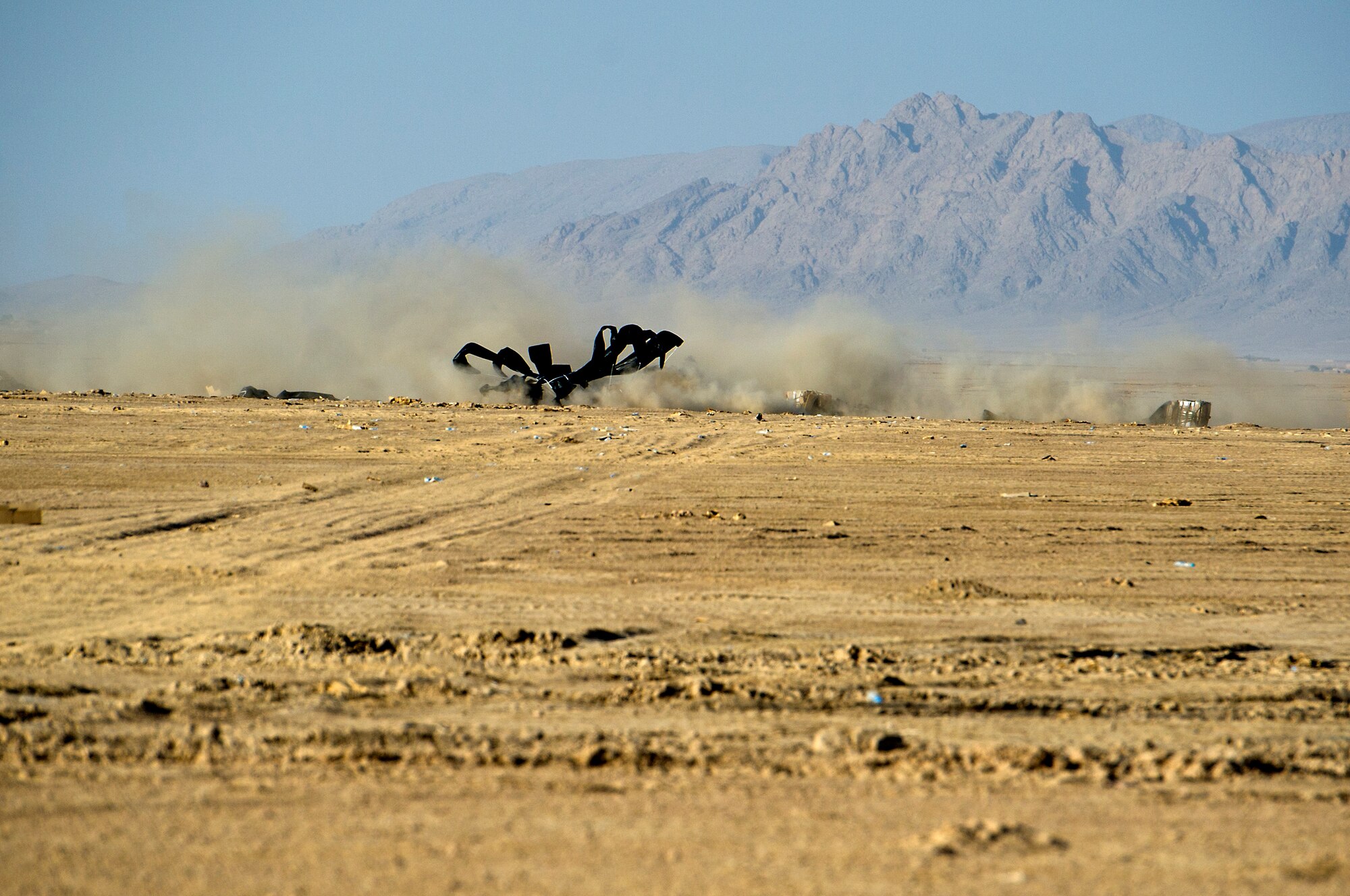 A bundle of food rations dropped from a U. S. Air Force C-130 Hercules creates a dust cloud when it lands on the Forward Operating Base Edinburgh drop zone on Oct 3, 2011. FOB Edinburgh is a logistics hub for Marines operating in the Northern Helmand Province. Aerial delivery of food and water allows Marines to get critical supplies without having to rely on risky ground convoys. (U.S. Air Force Photo/Master Sgt. Jeffrey Allen)