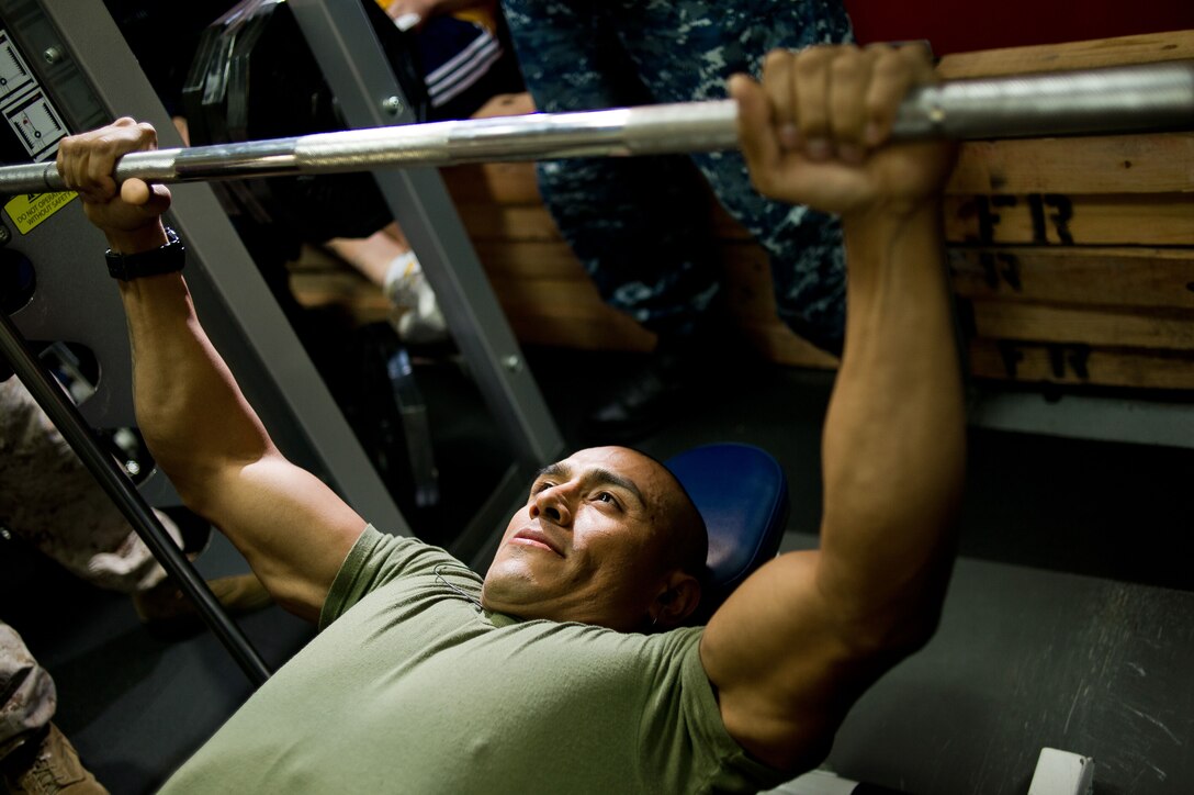 Gunnery Sgt. Cesar Andrade bench presses 225 pounds during a competition aboard the amphibious assault ship Makin Island Oct. 5. Gunnery Sgt. John Wellons won the competition by bench pressing 345 pounds. Andrade, 38, is from Portland, Ore., and serves as the company gunnery sergeant for Headquarters and Service Company, Battalion Landing Team 3/1. The battalion is the ground combat element for the 11th Marine Expeditionary Unit, which embarked USS Makin Island, the amphibious transport dock New Orleans and the dock landing ship Pearl Harbor in San Diego Sept. 28 and is participating in its final exercise before deploying in November.
