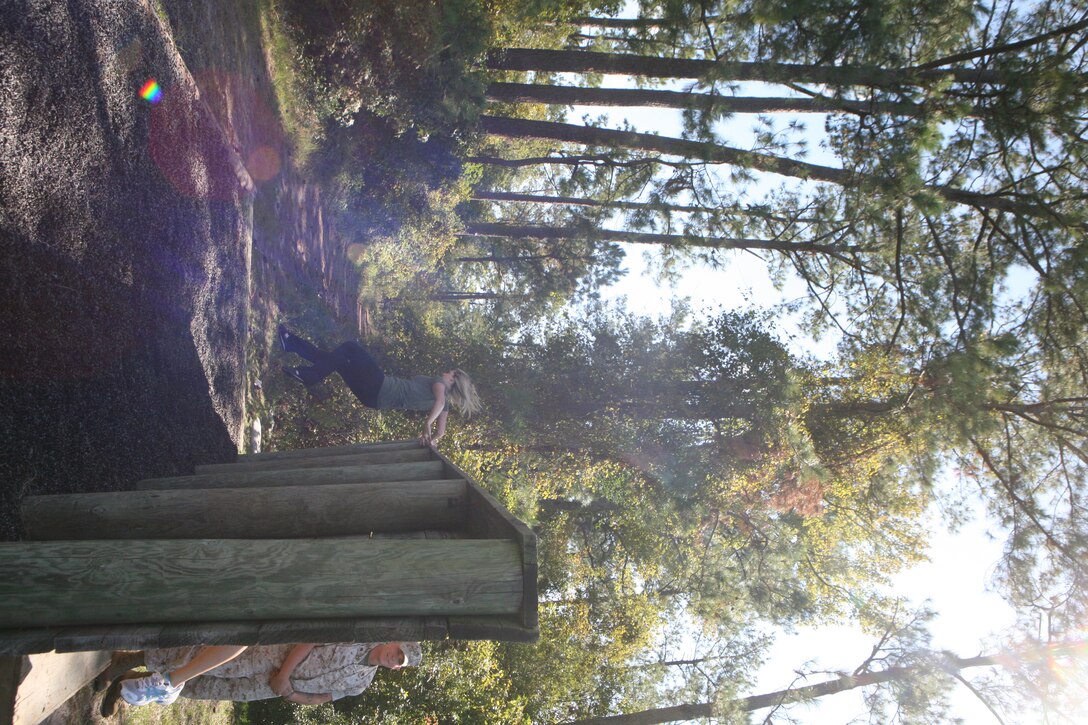 A spouse of a Marine with 2nd Amphibious Assault Battalion, 2nd Marine Division, jumps over a wall in an obstacle course during Jayne Wayne Day, Oct. 6. The battalion held a Jayne Wayne Day in order to give the family members a taste of Marine life.