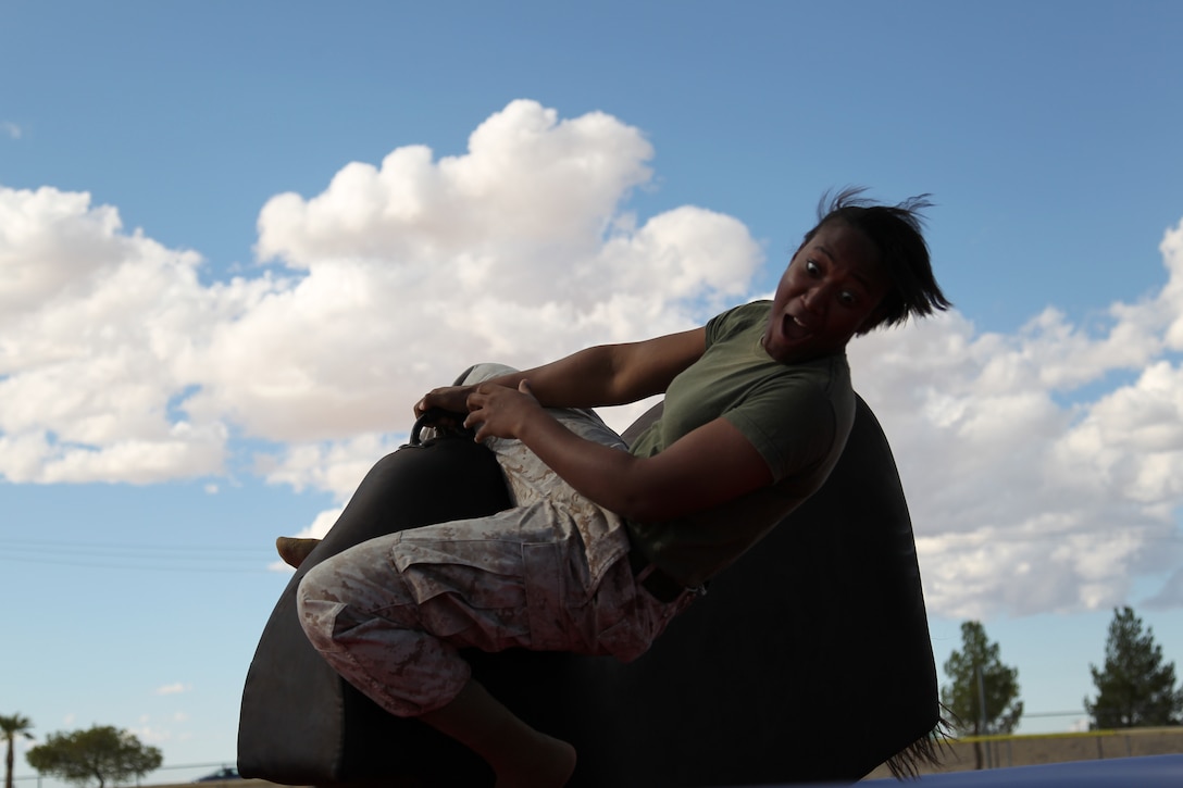 Sgt. Charlene Lewis, an Euphonium player with the Combat Center Band, resists being thrown from the mechanical bull during Headquarters Battalion’s Family Day at Felix Field Oct. 6, 2011.