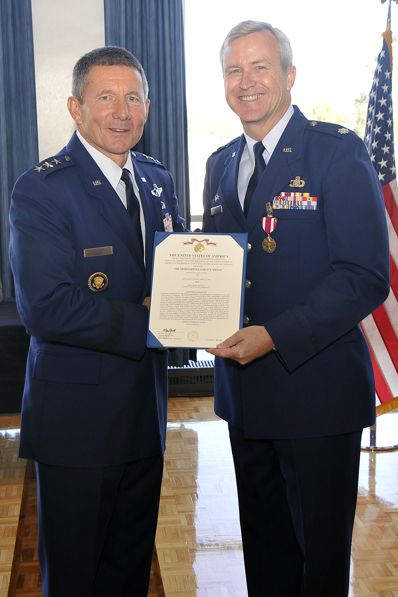 Lieutenant General Mike Gould, Superintendent of the United States Air Force Academy, presents newly promoted Colonel Larry Lang, Commander of the United States Air Force Academy Band, with his fourth Meritorious Service Medal. The MSM coincided with his promotion ceremony to full bird Colonel on 3 Oct 2011. Col Lang is only the ninth Colonel in Air Force Band history.