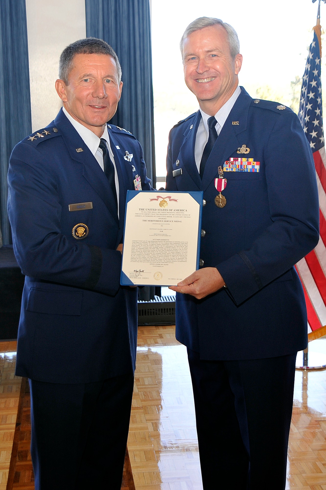 Lieutenant General Mike Gould, Superintendent of the United States Air Force Academy, presents newly promoted Colonel Larry Lang, Commander of the United States Air Force Academy Band, with his fourth Meritorious Service Medal. The MSM coincided with his promotion ceremony to full bird Colonel on 3 Oct 2011. Col Lang is only the ninth Colonel in Air Force Band history.