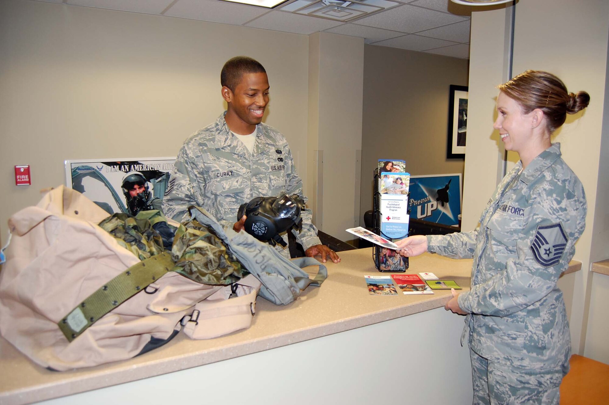 NELLIS AIR FORCE BASE, Nev. – (Left) Tech. Sgt. Natrell Curry, 926th Force Support Squadron knowledge operations manager, receives information about the Yellow Ribbon Program and other helping agencies upon his deployment from Master Sgt. Amy Bailey, 926th Force Support Squadron noncommissioned officer in charge of family readiness. (U.S. Air Force photo/Capt. Jessica Martin)