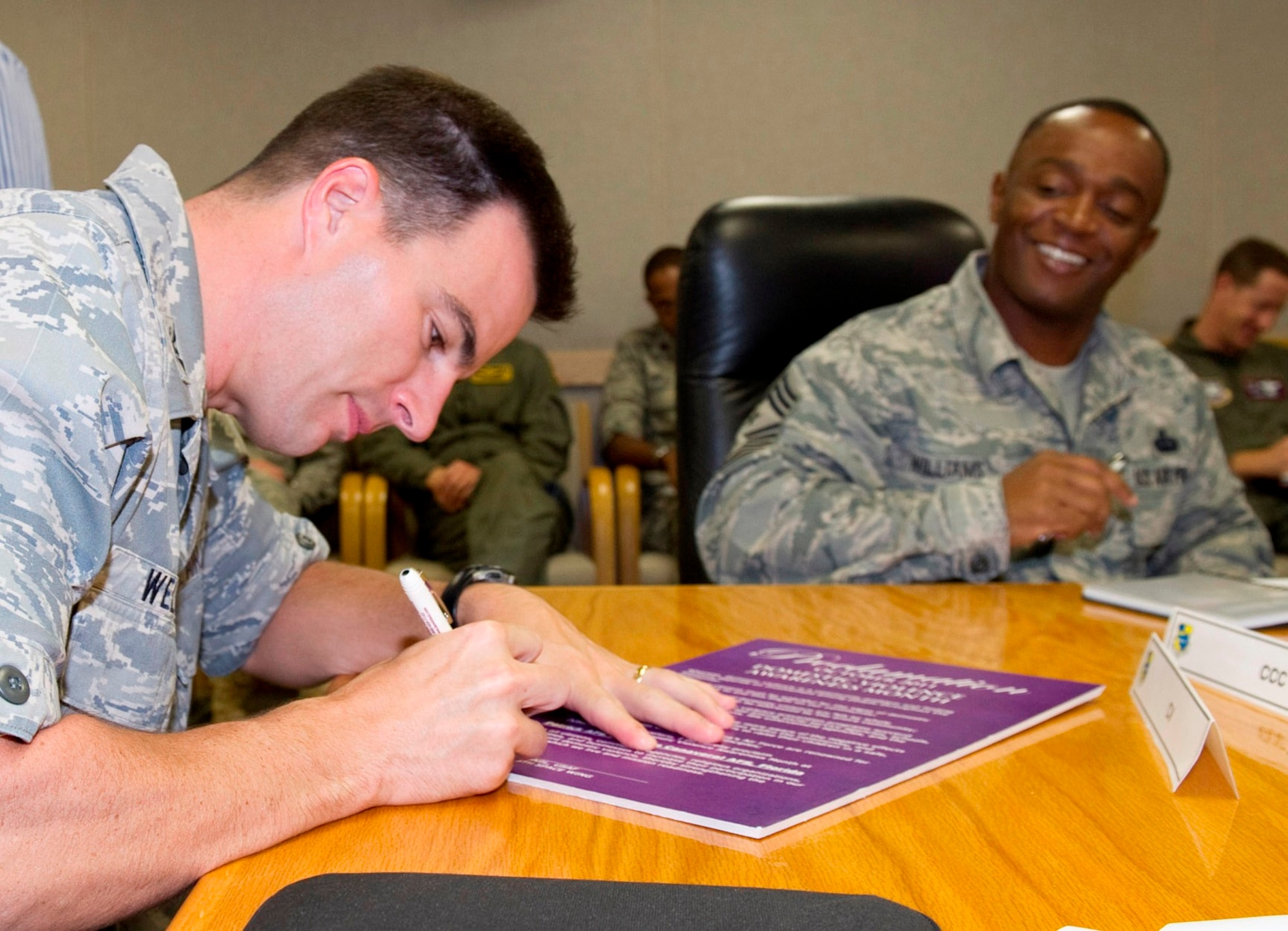 Col. Rory Welch, 45th Space Wing vice commander, signs the proclamation recognizing October as Domestic Violence Awareness Month, while Command Chief Master Sgt. Calvin Williams looks on. Domestic Violence is a cycle of behavior used to gain control, power, and intimidation over a spouse or intimate partner. It has no barriers; both men and women can be the abusers or the victims of domestic violence. (U.S. Air Force photo/Matthew Jurgens)