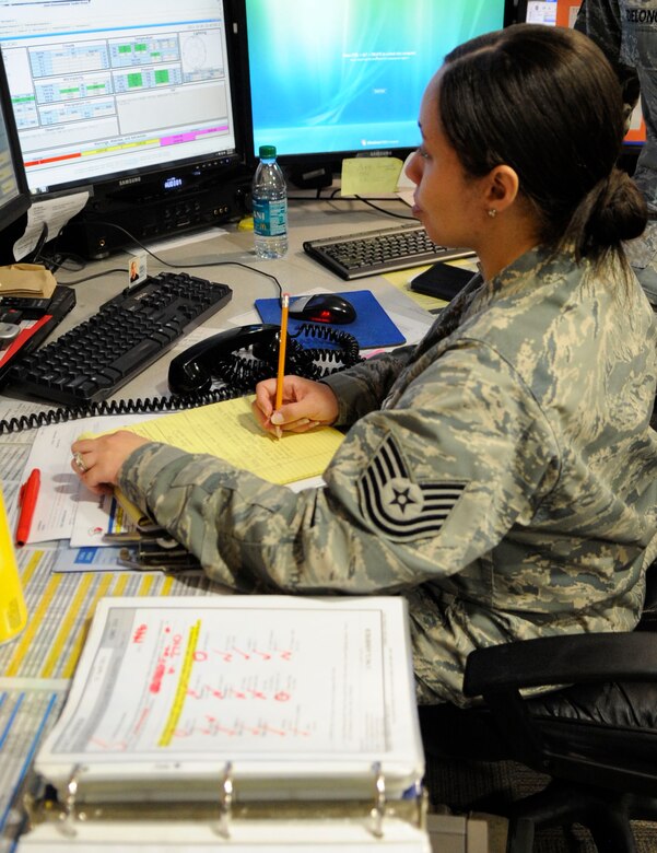 Tech. Sgt. Uridisee Johnson, Command Post emergency action controller, prepares for a Major Accident Response Exercise Oct. 5 on Barksdale Air Force Base, La. Johnson is one of many Airmen who keep the commander informed on situations occurring base wide.(U.S. Air Force photo/Airman 1st Class Andrea F. Liechti)(RELEASED)