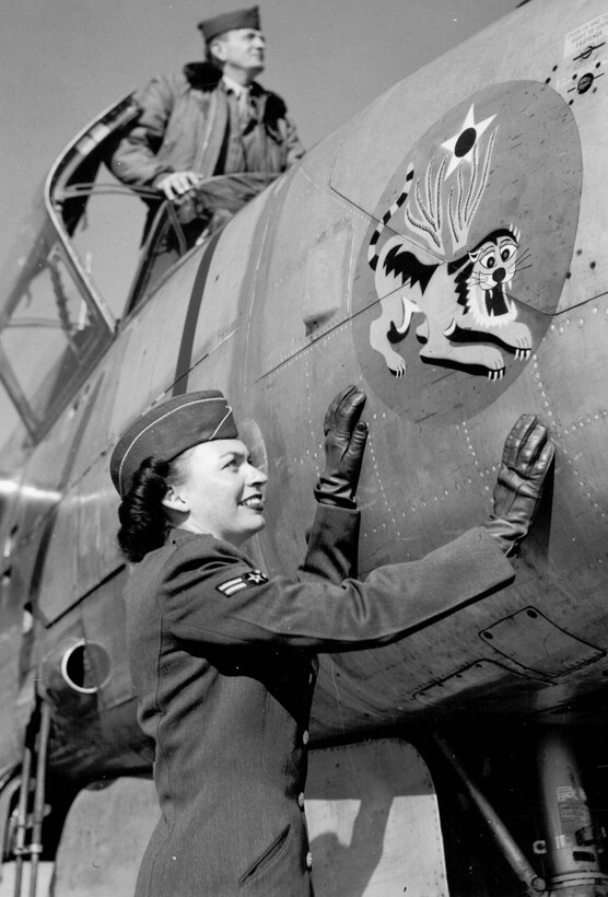 Airman Bettye Krieter looks at nose art on an Air Force fighter. As one of the first to serve in the Women in the Air Force (WAF), Krieter was activated during the Korean War. She retired from the Air Force Sept. 29, 2011, at Patrick Air Force Base, Fla., with a total of 63 years of federal service. (Air Force file photo)