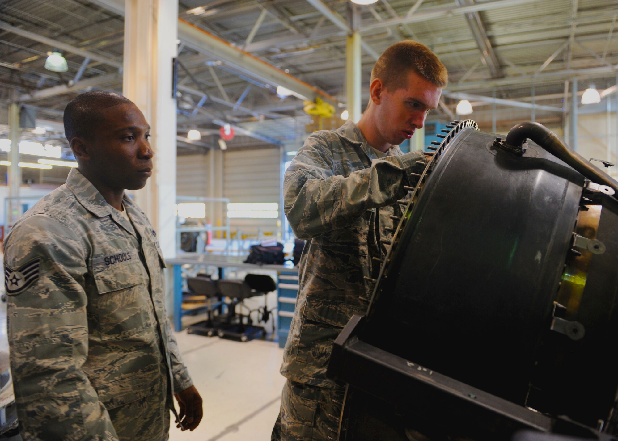 Staff Sgt. Riyyad Schools, 436th Training Squadron instructor, watches as Airman 1st Class Edward London, 7th Component Maintenance Squadron, works on a B-1 bomber engine, Oct. 3, 2011, at Dyess Air Force Base, Texas. Schools is currently on a special-duty assignment training to become a new B-1 training instructor. (U.S. Air Force photo by Airman 1st Class Cierra Bullock/Released)
