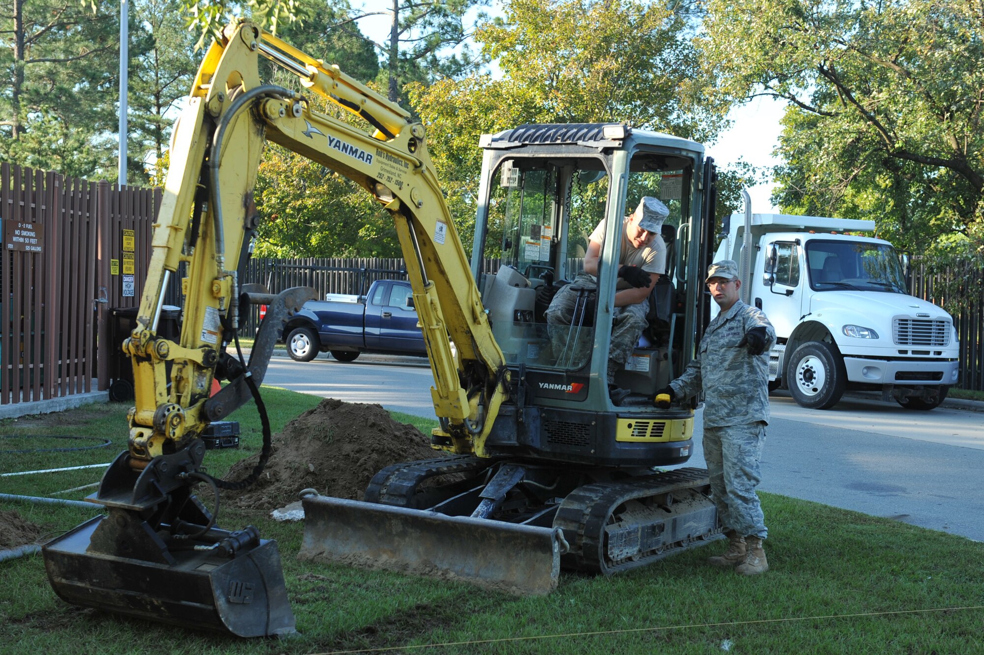 Staff Sgt. Christopher Mursh explains to Airman 1st Class Elliot Westerman the requirements before he begins digging during a visitor?s center project on Seymour Johnson Air Force Base, N.C., Oct. 4, 2011. An excavator is used to remove dirt to build a sidewalk, which allows the sidewalk to last longer without grass or weeds growing underneath and forming cracks. Mursh is a 4th Civil Engineer Squadron heavy equipment operator and hails from Whitesboro, N.Y. Westerman is a 4 CES heavy equipment operator and hails from Boswell, Penn. (U.S. Air Force photo by Senior Airman Whitney Stanfield)