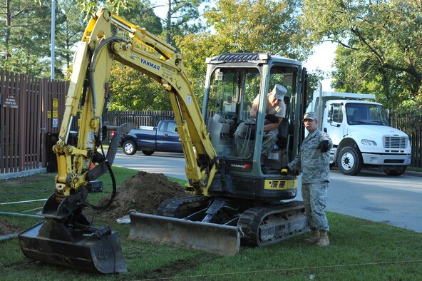 Staff Sgt. Christopher Mursh explains to Airman 1st Class Elliot Westerman the requirements before he begins digging during a Visitor's Center project on Seymour Johnson Air Force Base, N.C., Oct. 4, 2011. An excavator is used to remove dirt to build a sidewalk, which allows the sidewalk to last longer without grass or weeds growing underneath and forming cracks. Mursh is a 4th Civil Engineer Squadron heavy equipment operator and hails from Whitesboro, N.Y. Westerman is a 4 CES heavy equipment operator and hails from Boswell, Penn. (U.S. Air Force photo by Senior Airman Whitney Stanfield) 

