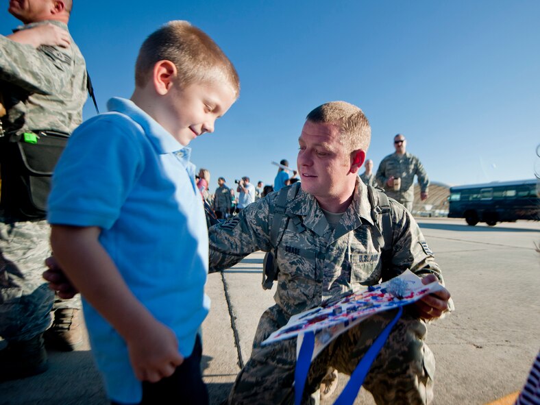 U.S. Air Force Staff Sgt. Richard Chase, 23rd Equipment Maintenance Squadron, speaks with his son, Joshua, after returning home from deployment Oct. 6, 2011, at Moody Air Force Base, Ga. During the six-month deployment to Kandahar Air Field, Afghanistan, Chase was part of a unit that helped support and maintain the A-10C Thunderbolt II aircraft. (U.S. Air Force photo by Staff Sgt. Jamal D. Sutter/Released)
