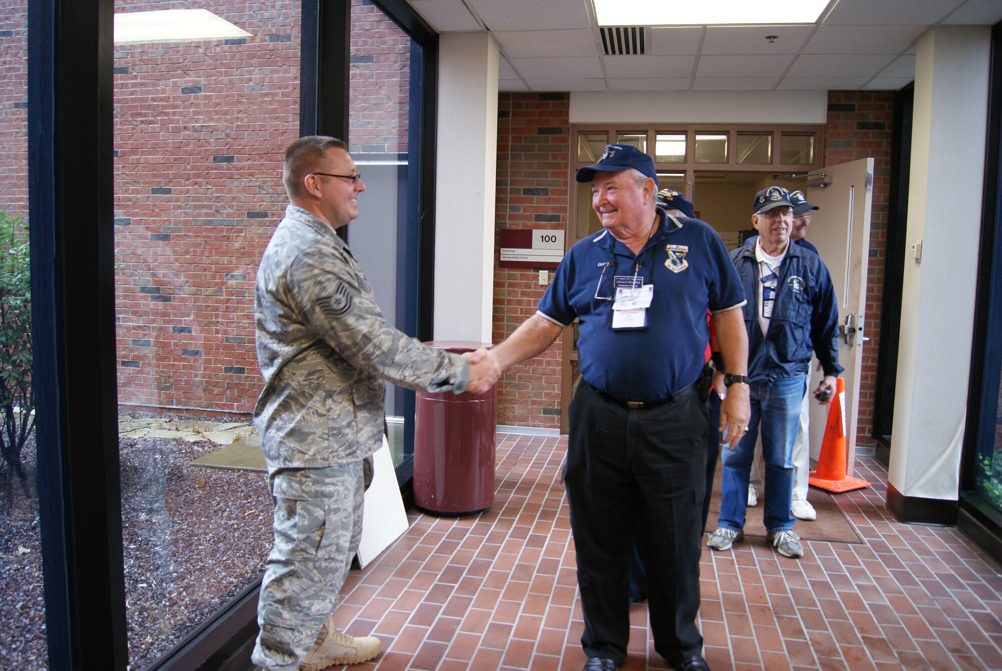 SCOTT AIR FORCE BASE, Ill. – Retired Maj. Gen. Gerald Prather, former commander of the Air Force Communications Command, shakes hands with Tech. Sgt. Christopher Wolf, Technology and Interoperability Facility operations supervisor, during a tour of the facility Sept. 22. (U.S. Air Force photo/ Melisse Noud)