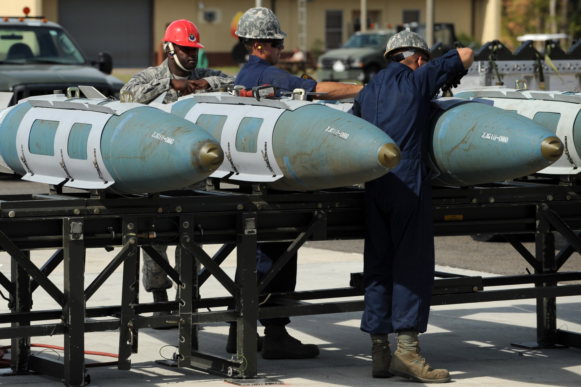 A member of the Global Strike Challenge team (red hard hat) evaluates 307th Maintenance Squadron munitions technicians as they assemble simulated 2000-pound Joint Direct Attack Munitions at Barksdale Air Force Base, La., Oct. 5, 2011. The Global Strike Challenge is the world's premier bomber, Intercontinental Ballistic Missile and security forces competition with units from the Air Force Global Strike Command, Air Combat Command, Air Force Reserve Command and the Air National Guard, and the official score-posting will be at Barksdale, Nov 8-9. (U.S. Air Force photo by Master Sgt. Greg Steele/Released)
