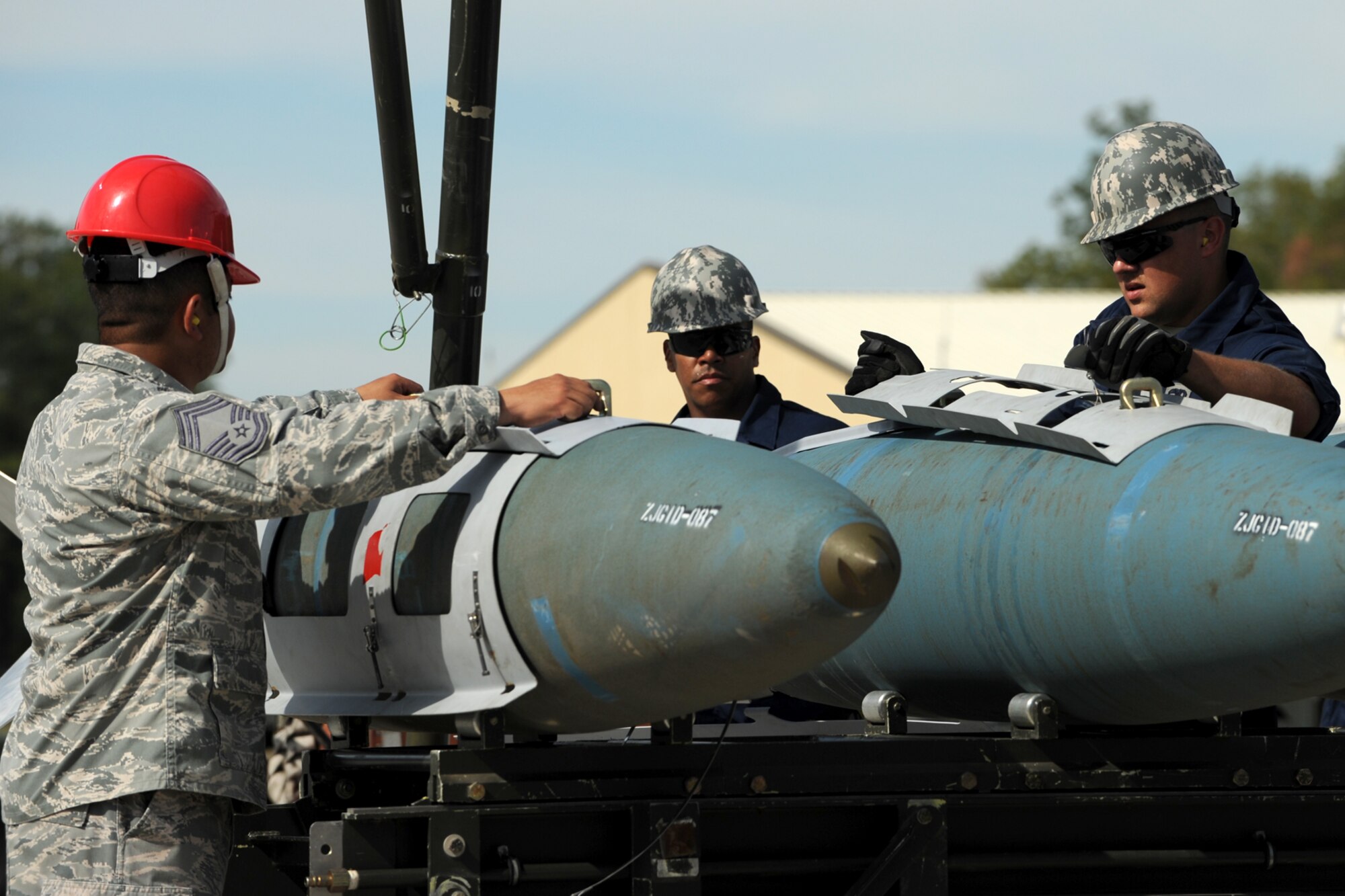 A member of the Global Strike Challenge team (red hard hat) evaluates 307th Maintenance Squadron munitions technicians as they assemble simulated 2000-pound Joint Direct Attack Munitions at Barksdale Air Force Base, La., Oct. 5, 2011. The Global Strike Challenge is the world's premier bomber, Intercontinental Ballistic Missile and security forces competition with units from the Air Force Global Strike Command, Air Combat Command, Air Force Reserve Command and the Air National Guard, and the official score-posting will be at Barksdale, Nov 8-9. (U.S. Air Force photo by Master Sgt. Greg Steele/Released)