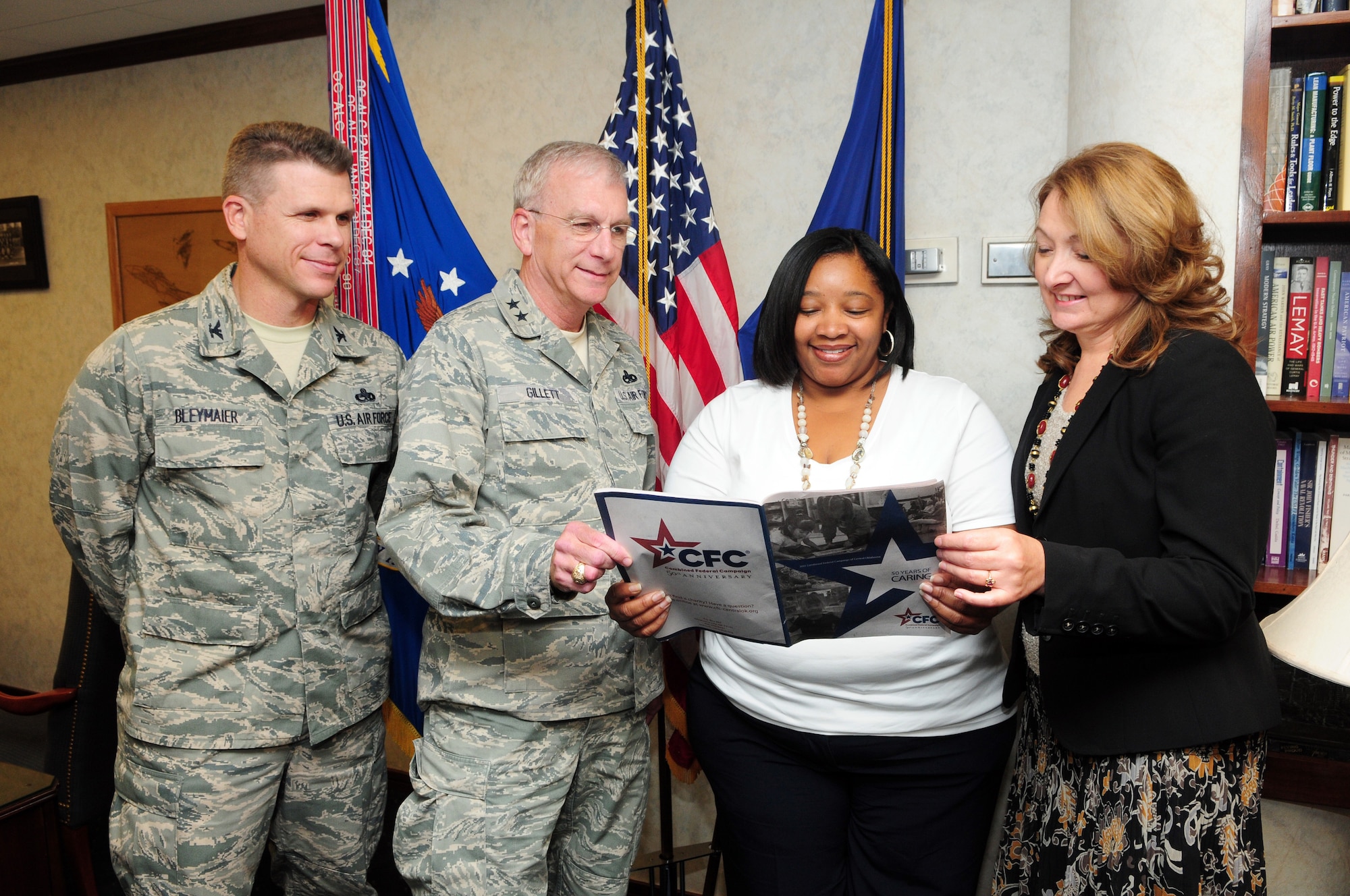 Oklahoma City Air Logistics Center senior leaders, Col. Stephen Bleymaier, OC-ALC vice commander; Maj. Gen. David Gillett, OC-ALC commander; and Laura Culberson, OC-ALC director of staff, look through the 2011 Combined Federal Campaign booklet with Tinker’s CFC coordinator Stacia Hathorn before signing their pledge cards. This year’s campaign kicked off Oct. 5 and runs through Nov. 16. (Air Force photo by Kelly White)