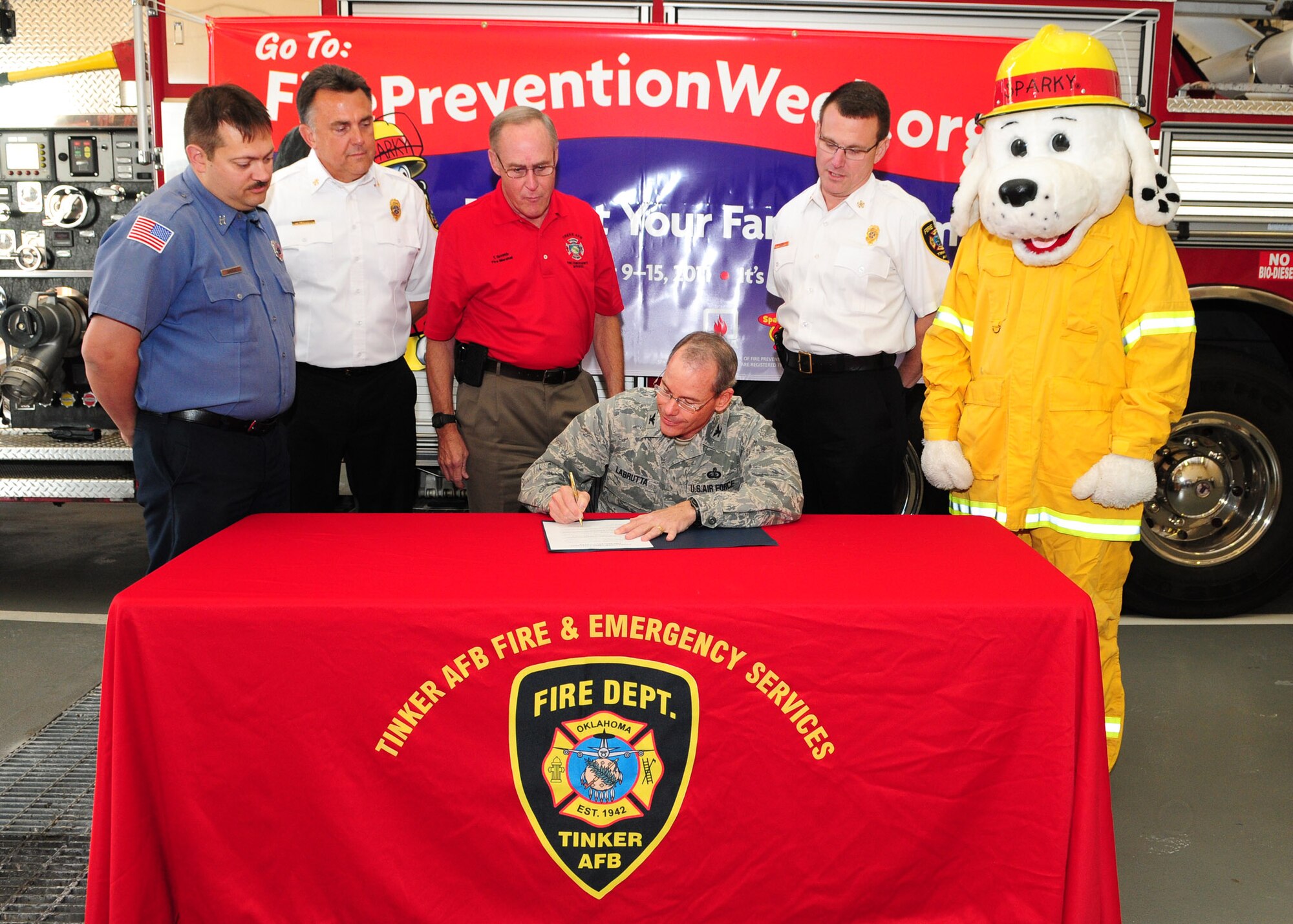 Flanked by members of 72nd Air Base Wing Civil Engineer Directorate Fire and Emergency Services and Sparky the Fire Dog, Col. Bob LaBrutta signs the Fire Prevention Week proclamation. With the 72nd ABW commander are, from left, Capt. Todd Lambert, Assistant Chief of Fire Prevention Scott Bloxham, CE Director Robert Griffin and Fire Chief Terry Ford. For more on Fire Prevention Week, see page 1a. (Air Force photo by Kelly White)