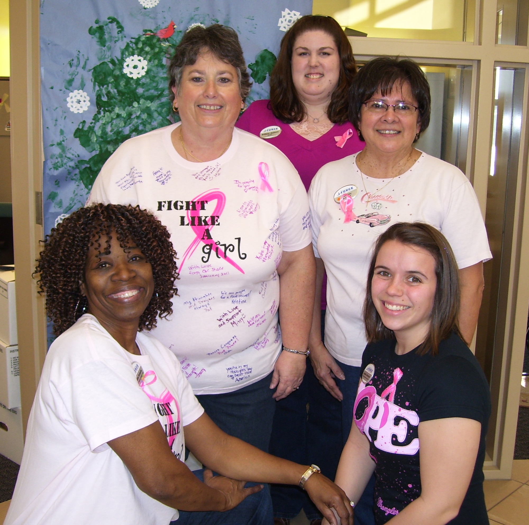 WHITEMAN AIR FORCE BASE, Mo. -- (Middle left) Julie Jolly, 509th Child Development Center director, with staff members, prior to the start of her radiation and chemotherapy. Staff members surprised Julie with a Breast Cancer Awareness pink T-shirt filled with prayers and supportive messages from other staff members. Front: Hattie Roberts, Leslie Johansen; Middle:  Julie Jolly, Aida Dey and back: Brittany Jackson