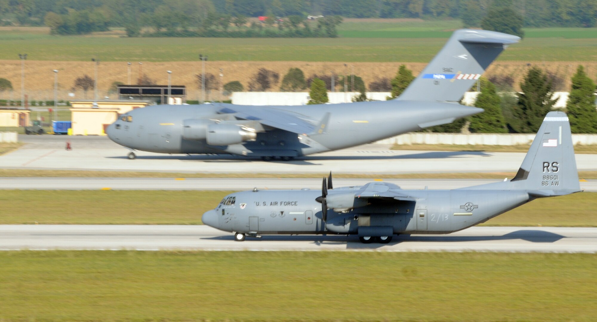 A C-17 Globemaster and a C-130 Hercules waits on the flight line Oct. 5 at Aviano Air Base, Italy, to be boarded by the 173rd Airborne Brigade Combat Team's first full-spectrum training in Europe. The 173rd ABCT, stationed in Vicenza, Italy, is leading the effort in the first brigade-sized operation in Europe since 2003 that includes more than 3,500 U.S. military and joint partner nation paratroopers. (U.S. Air Force photo/Airman 1st Class Jenay Randolph)
