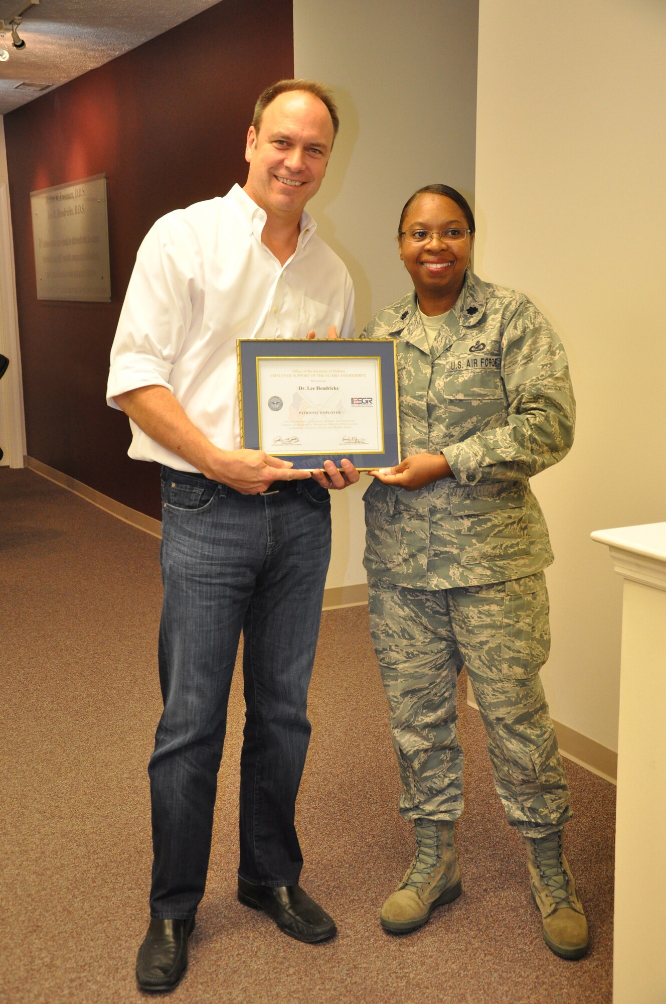 WRIGHT-PATTERSON AIR FORCE BASE, Ohio – Lt. Col. Cynthia Harris, 445th Airlift Wing, presents Dr. Lee Hendricks with the Employer Support of the Guard and Reserve Patriot Award Oct. 4 in recognition for his support of Mrs. Leslie Hutchison, wife of Tech. Sgt. Jason Hutchison, 445th Aeromedical Evacuation Squadron. Leslie nominated Drs. Hendricks and James Freeman for the award for their support of her and her family while her husband was deployed. (U.S. Air Force photo/Stacy Vaughn)