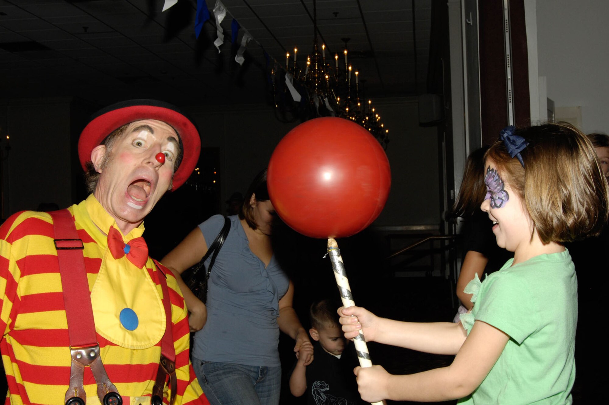HANSCOM AIR FORCE BASE, Mass. – Davey the Clown helps Hailey Bobak balance a ball during Oktoberfest at the Minuteman Commons Sept. 30. The annual fall event included German food and beverages, polka and waltz music, fun and games for the kids and more. (U.S. Air Force photo by Linda LaBonte Britt)