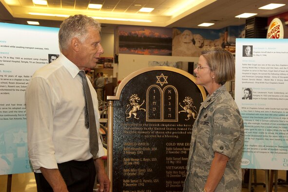 HANSCOM AIR FORCE BASE, Mass. – Col. Stacy L. Yike (right), 66th Air Base Group commander, speaks with Bruce Schlossberg in front of a memorial honoring fallen Jewish military chaplains during a tour stop at the base Exchange Sept. 30. The monument is making stops along the east coast at military installations, state houses and synagogues before being placed alongside other chaplain memorials at Arlington National Cemetery Oct. 24. (U.S. Air Force photo)