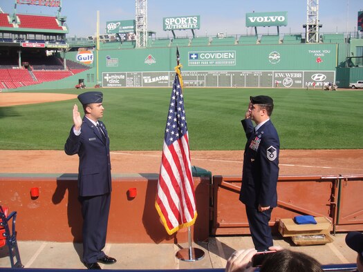 BOSTON - Master Sgt. Christopher Spann (right), from the Cyber/Netcentric Directorate, reenlists in the Air Force with the help of his brother, 1st Lt. Gary Spann, at Fenway Park Sept. 27 as friends and family watch. Sergeant Spann was also recently promoted to senior master sergeant. (Courtesy photo)