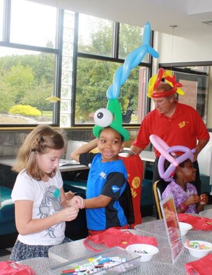 HANSCOM AIR FORCE BASE, Mass. – Skye Whitlow, Josiah Russell and Sophie Russell (left to right) try on balloon animal hats in the 13th Frame Diner during the Special Needs Family Fun and Information Fair Sept. 24. The event was held at Hanscom Lanes for families from all service branches with children with special needs. Attendees could take part in activities and receive information from base and community resource representatives. (Courtesy photo)