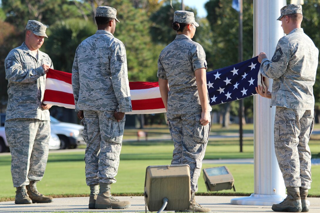 Members of 1st Air Force fold the flag during a formal Air Force Retreat ceremony at the 325th Fighter Wing Flag Park at Tyndall Air Force Base, Fla., Oct. 5. Retreat is military tradition that pays tribute to the American flag and signifies the end of the duty day. (U.S. Air Force photo by Angela Pope) 