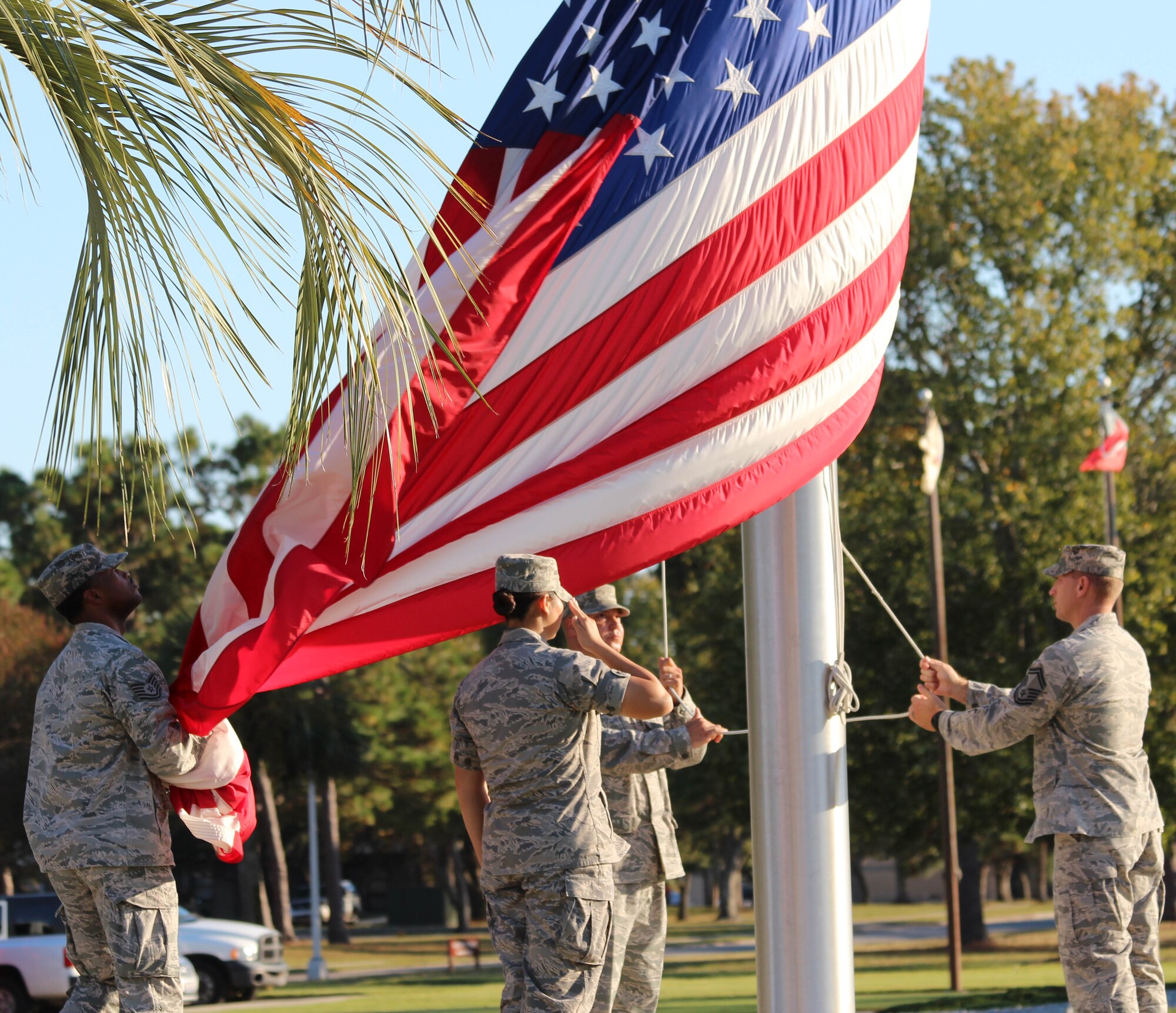 Members of 1st Air Force lower the flag during a formal Air Force Retreat ceremony at the 325th Fighter Wing Flag Park at Tyndall Air Force Base, Fla., Oct. 5. Retreat is military tradition that pays tribute to the American flag and signifies the end of the duty day. (U.S. Air Force photo by Angela Pope) 