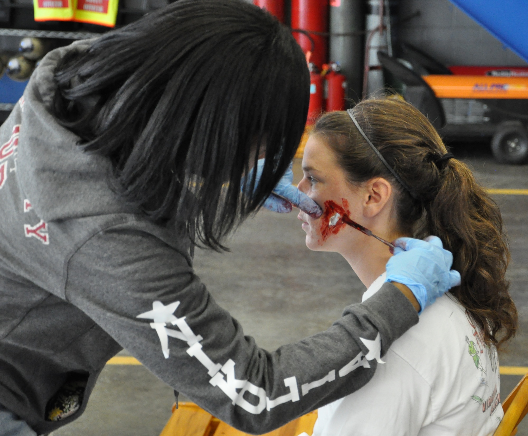 Staff Sgt. Nikolia Saunders, 633rd Medical Group medic, applies moulage to a Denbigh High School student during the Newport News-Williamsburg International Airport’s disaster response mass casualty exercise Oct. 5. The six-person team applied realistic, movie-style wound makeup to a group of 50 Denbigh High School students who acted as victims of a simulated aircraft crash at the airport. (U.S. Air Force photo by Senior Airman Jason J. Brown/RELEASED)