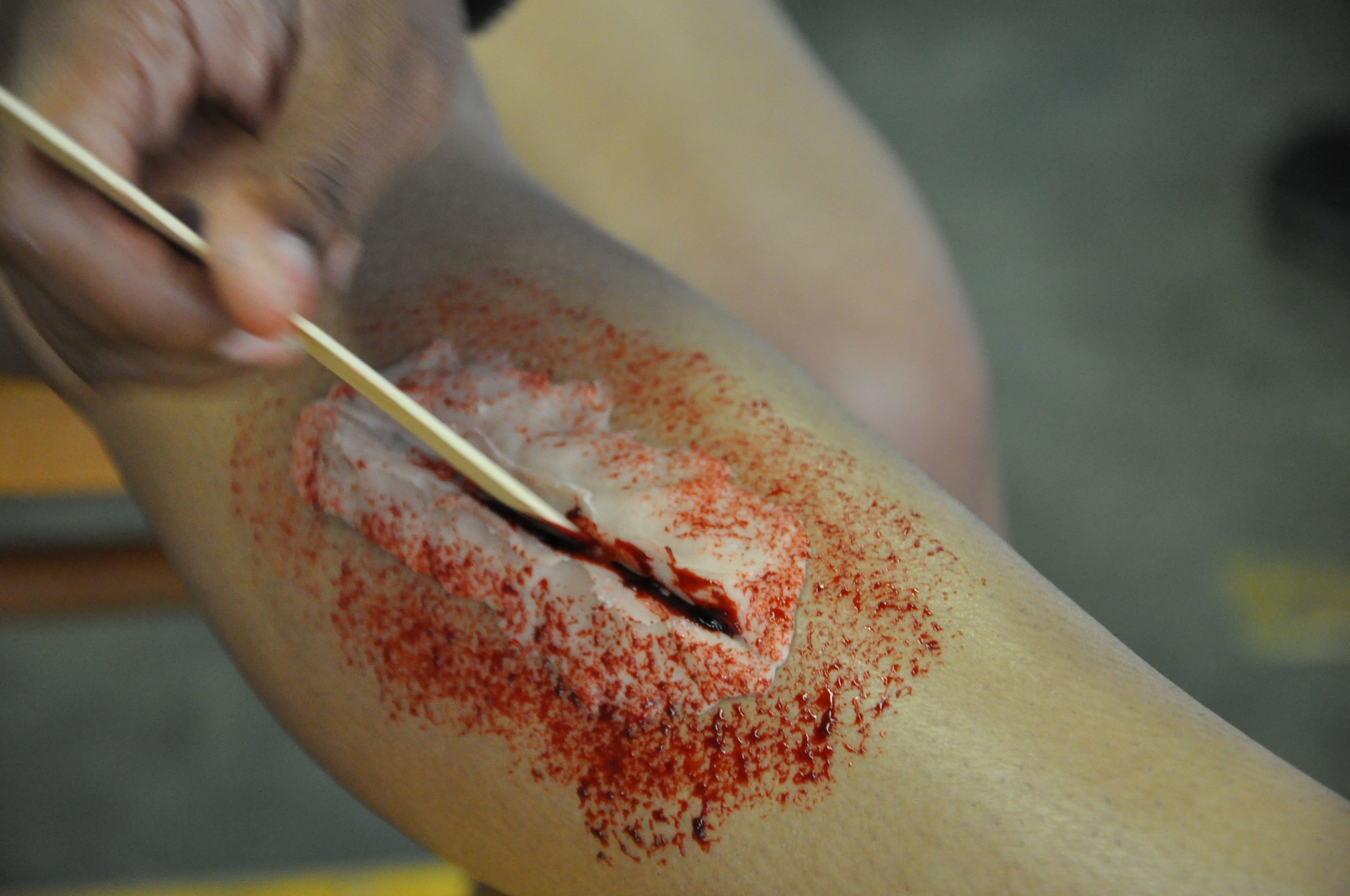 Staff Sgt. Monica Fray, 633rd Medical Group medic, adds intricate detail to a moulage wound on a Denbigh High School student during the Newport News-Williamsburg International Airport’s disaster response mass casualty exercise Oct. 5. Fray said the experience was fun, and was a great opportunity to reach out to the community. (U.S. Air Force photo by Senior Airman Jason J. Brown/RELEASED)