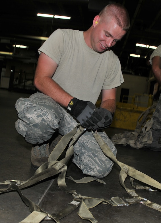 Airman 1st Class Brandon Fritz readies a side net, which will be used to secure a pallet carrying water purification systems Oct. 5, at Joint Base Charleston-Air Base. Humanitarian aid, including 20 reverse osmosis water purification systems and two anesthesia machines, will be sent to Colon, Honduras Oct. 25. These supplies will assist more than 20,000 Hondurans in need. Fritz is an air transportation specialist from the 437th Aerial Port Squadron. (U.S. Air Force photo/Airman 1st Class Jared Trimarchi)