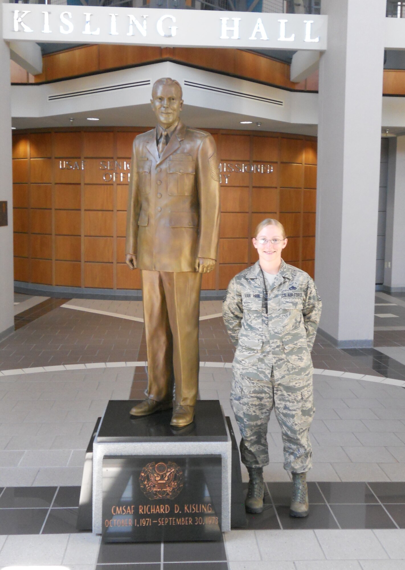 Master Sgt. Julie Van Hise stands next to a statue of former Chief Master Sergeant of the Air Force Richard D. Kisling at the Senior NCO Academy. (Courtesy photo)