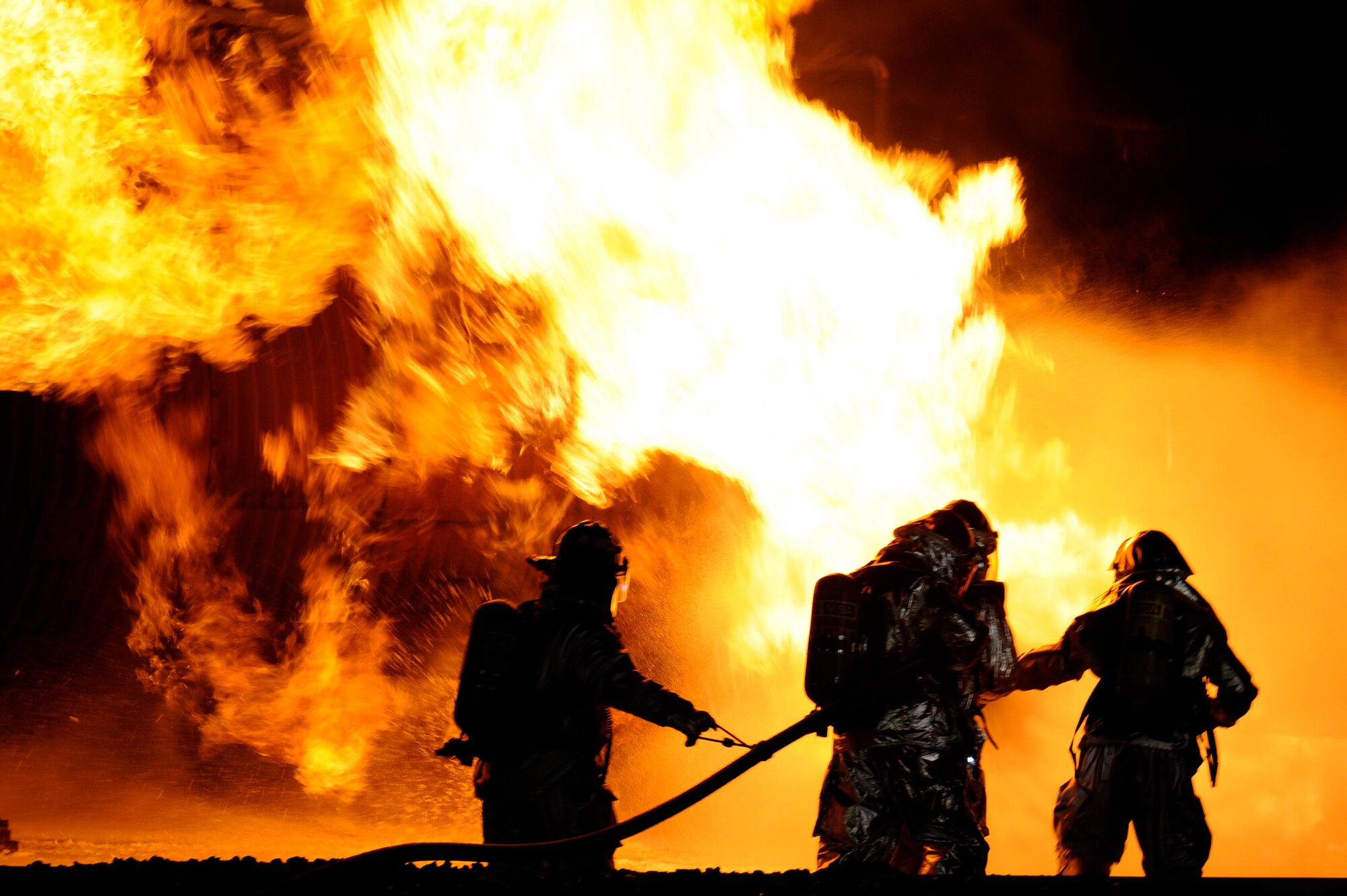 MISAWA AIR BASE, Japan - Firefighters from the 35th Civil Engineer Squadron assist distinguished visitors from Misawa Air Base with extinguishing a fire at a nighttime demonstration during Fire Prevention Week here Oct. 5. The 35 CES fire department invited the Misawa community out for nighttime fire demonstrations to help promote Fire Prevention Week. This week the 35 CES has been educating the Misawa community on fire prevention in order to achieve their goal of zero mishaps. (U.S. Air Force photo/Tech. Sgt. Marie Brown)