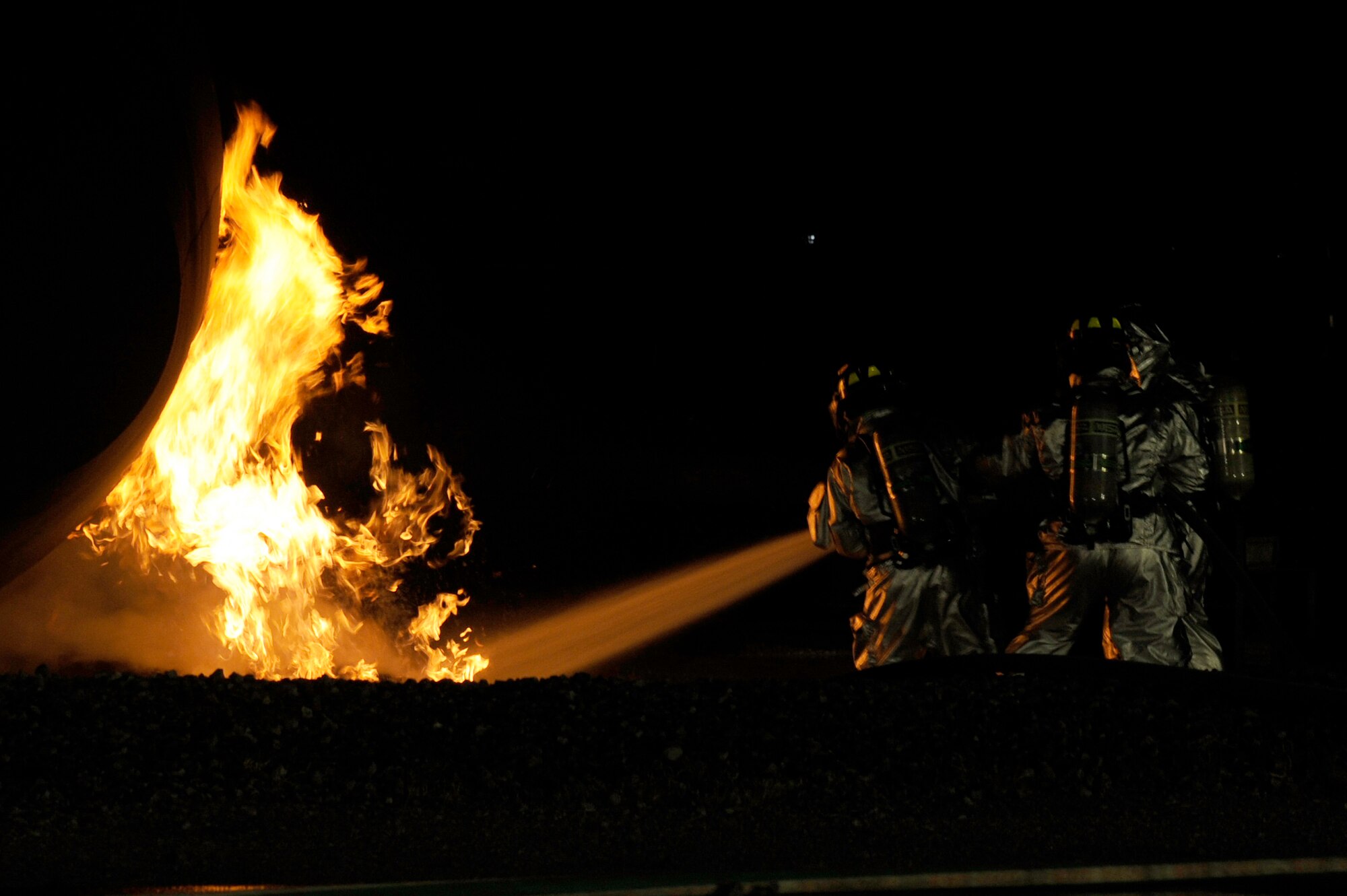 MISAWA AIR BASE, Japan - Firefighters from the 35th Civil Engineer Squadron assist distinguished visitors from Misawa Air Base with extinguishing a fire at a nighttime demonstration during Fire Prevention Week here Oct. 5. The 35 CES fire department invited the Misawa community out for nighttime fire demonstrations to help promote Fire Prevention Week. This week the 35 CES has been educating the Misawa community on fire prevention in order to achieve their goal of zero mishaps. (U.S. Air Force photo/Tech. Sgt. Marie Brown)
