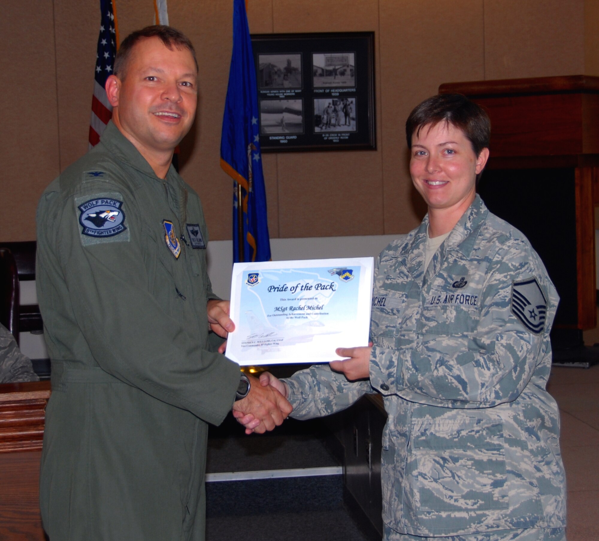 Col. Stephen C. Williams, 8th Fighter Wing vice commander, presents the Pride of the Pack award to Master Sgt. Rachael Michel, 8th Maintenance Group resource advisor, at Kunsan Air Base, Republic of Korea, Oct. 6. (U.S. Air Force photo by Capt. Omar Villarreal/Released)