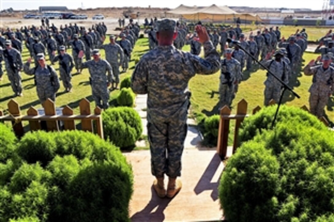 With their hands raised, 126 U.S. service members rehearse before a mass re-enlistment ceremony on Al Asad Air Base, Iraq, Oct. 5, 2011.


