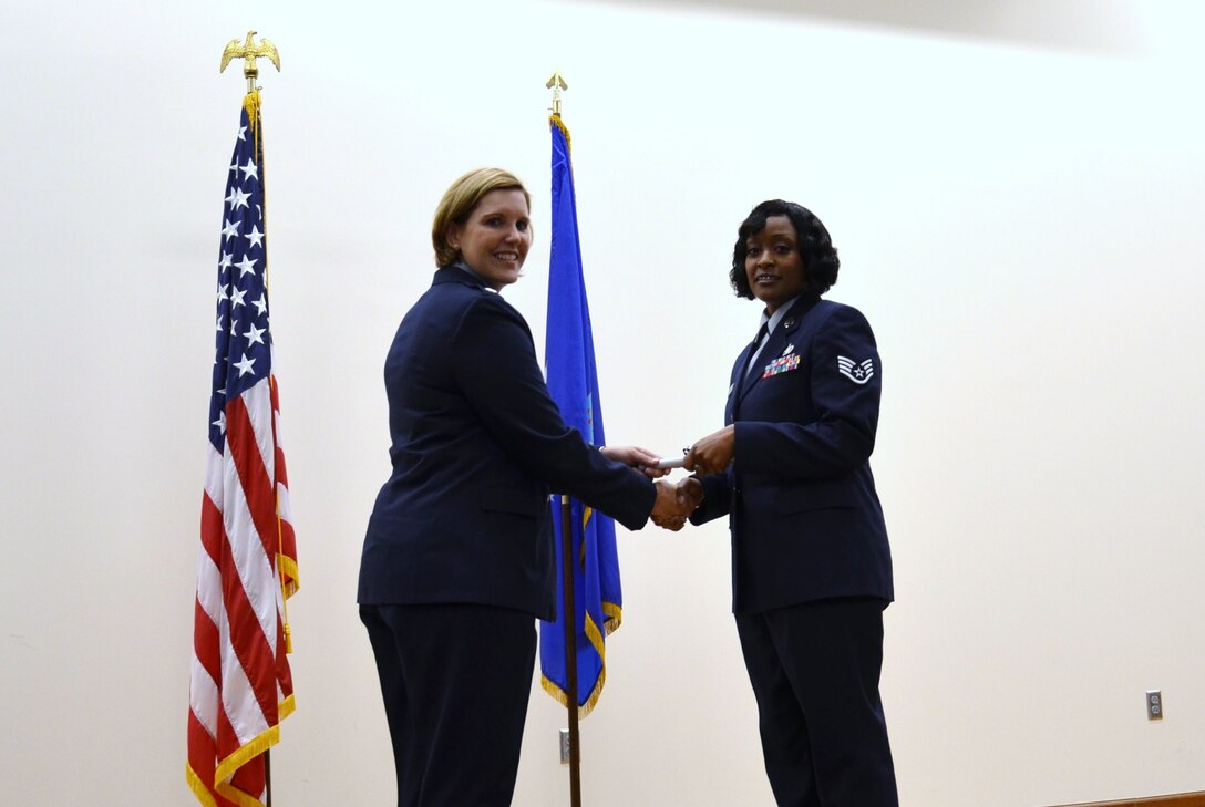 Air Force Staff Sgt. Deondra Parks accepts her certificate of completion from Air Force Lt. Col Elizabeth Decker, squadron commander for the 383rd Training Squadron, during the Basic Medical Technician/Corpsman Program graduation ceremony at the 
Medical Education & Training Campus (METC) in Fort Sam Houston, Texas on Oct 3, 2011. Parks  was enrolled in the program at Sheppard Air Force Base in 2010 but had to drop from training after she was shot. She returned to training in June 2011 at 
METC where the program is now being taught. (U.S. Navy photo by Lisa Braun/Released)
