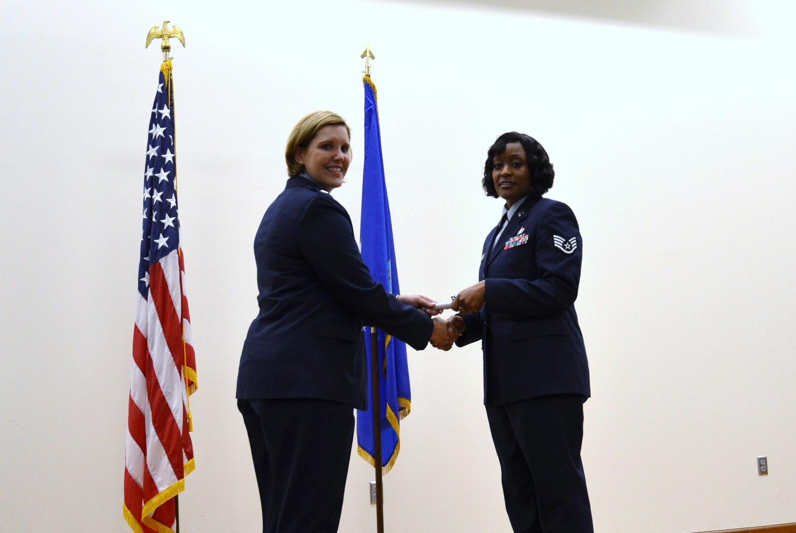 Air Force Staff Sgt. Deondra Parks accepts her certificate of completion from Air Force Lt. Col Elizabeth Decker, squadron commander for the 383rd Training Squadron, during the Basic Medical Technician/Corpsman Program graduation ceremony at the 
Medical Education & Training Campus (METC) in Fort Sam Houston, Texas on Oct 3, 2011. Parks  was enrolled in the program at Sheppard Air Force Base in 2010 but had to drop from training after she was shot. She returned to training in June 2011 at 
METC where the program is now being taught. (U.S. Navy photo by Lisa Braun/Released)
