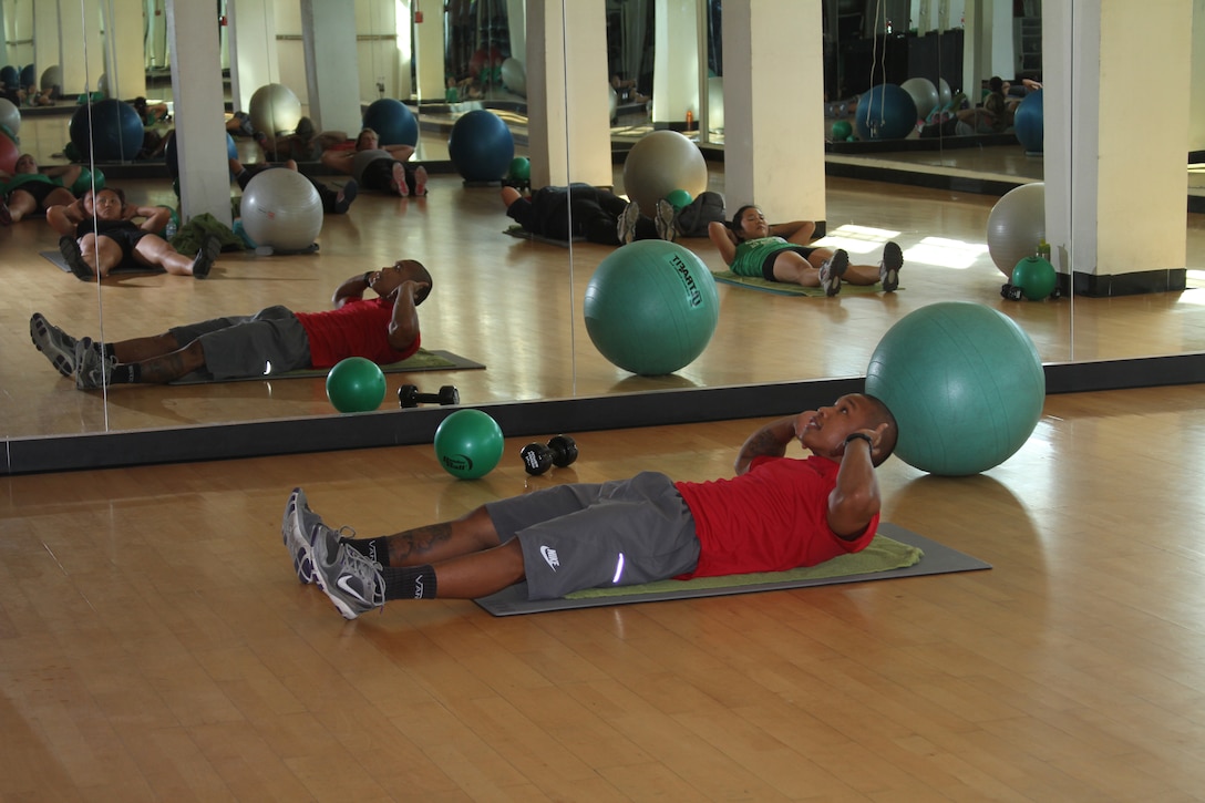 Gene Calantoc, Semper Fit personal trainer, performs basic crunches during an abs class at the Marine Corps Recruit Depot San Diego Semper Fit Center. Calantoc leads participants through a variety of abdominal exercises using different equipment, targeting different core muscles Monday through Thursday. Having a knowledgeable instructor can make it easier for some people to achieve their fitness goals.