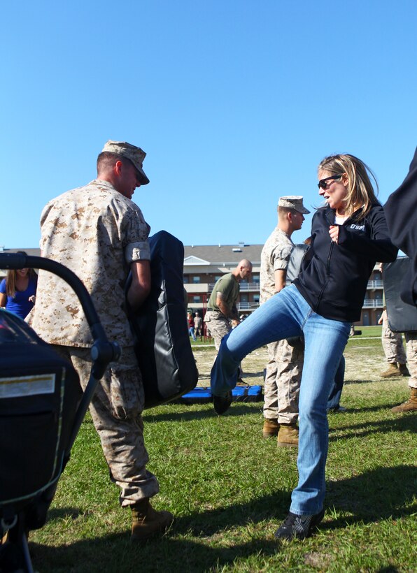 Lindsey Zach, a native of Troy, Mich. , kicks her husband, Lance Cpl. Michael Zach, with Weapons Company, 1st Battalion, 2nd Marine Regiment, while conducting Marine Corps Martial Arts Program movements during Jane Wayne Day  on Camp Lejeune, N.C., Oct. 6, 2011. Spouses and families of the 24th Marine Expeditionary Unit's Battalion Landing Team came together to participate in various events such as MCMAP, Combat Fitness Test, and Rifle Marksmanship.