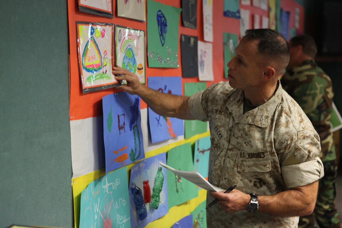 Col.Daniel J. Lecce; the commanding officer aboard Marine Corps Base Camp Lejeune looks at a picture submitted by a child for the Energy Awareness Poster Contest. It was one of 55 entries to the contest. (Official U.S. Marine Corps photo by Pfc. Jackeline M. Perez Rivera)