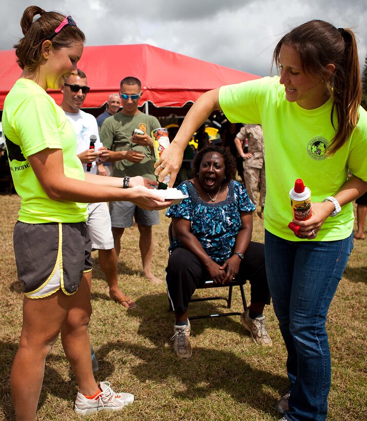 Casey S. Fleishmann (right), family readiness officer, Headquarters and Service Battalion, U.S. Marine Corps Forces, Pacific, and 1st Lt. Kerry Friedewald (left), adjutant, HqSvcBn, prepare a pie for the “pie in the face” fundraiser at the Bordelon Bash at Bordelon Field here Oct 7. The Bordelon Bash was a family fun day event hosted by the battalion.