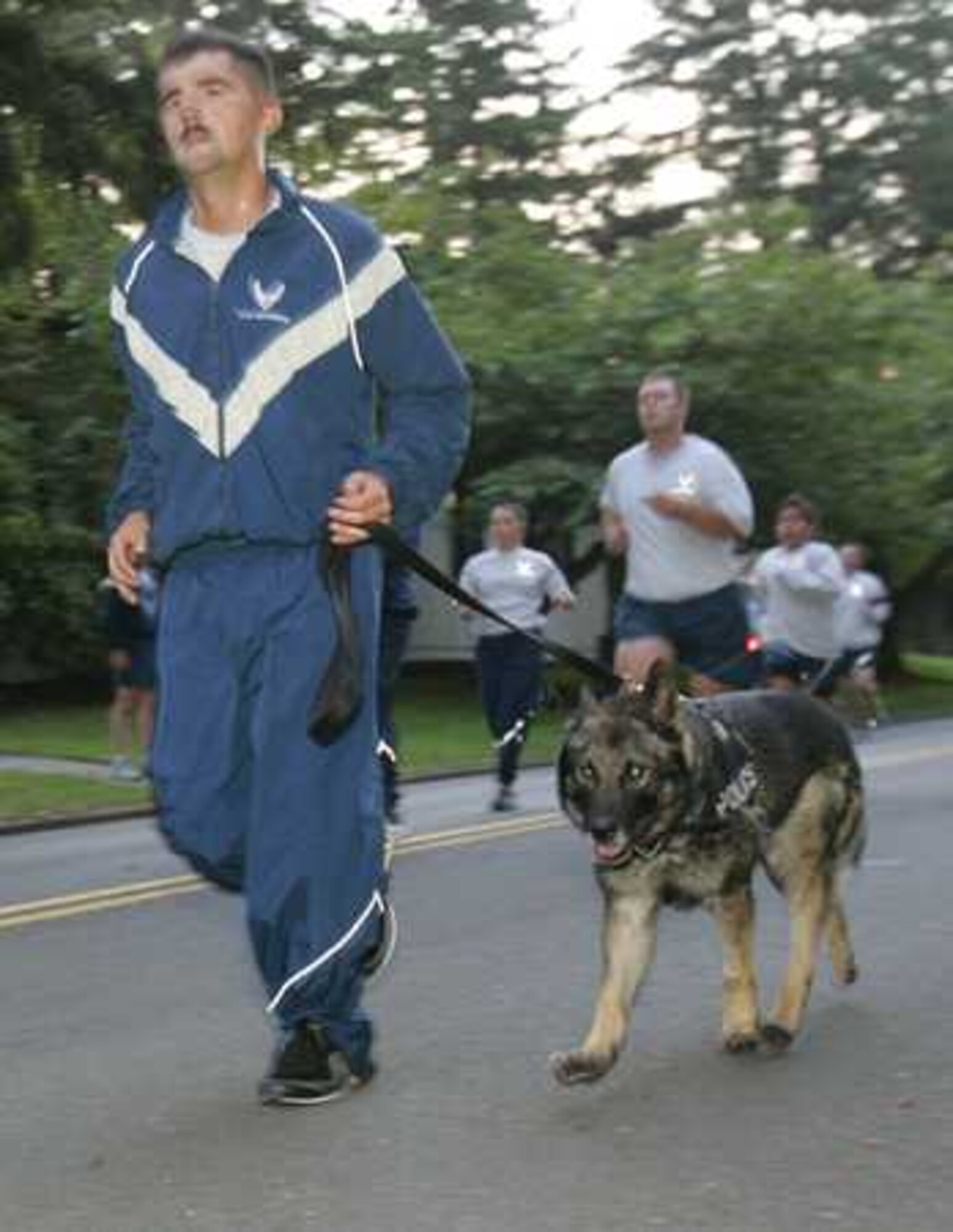 Senior Airman Richard Lynn run with his eight-year-old K-9, Meki, while participating in the Friday run September 30, 2011 on Joint Base Lewis-McChord, Wash. (Courtesy photo/David Poe)