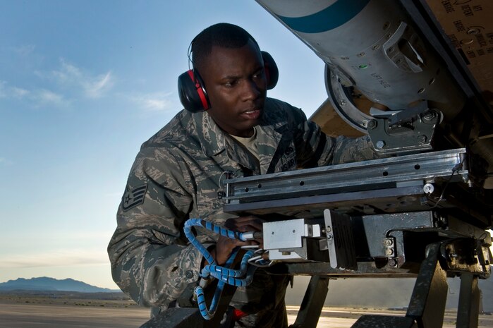 U.S. Air Force Staff Sgt. Chris Sims, 757th Aircraft Maintenance Squadron aircraft armament systems journeyman, guides an Aim-120 Missile onto a F-15 Eagle during a weapons load crew competition Oct. 7, 2011, at Nellis Air Force Base, Nev. Weapons load competitions are conducted quarterly to keep Airmen sharp and recognize superior performers. Weapons load teams are evaluated for use of the checklist, safety, and overall speed. (U.S Air Force photo by Airman 1st Class Daniel Hughes/Released)