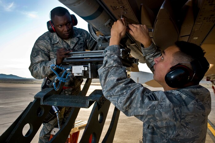 From left, U.S. Air Force Staff Sgt. Chris Sims and Senior Airman Phillip Hohner, 757th Aircraft Maintenance Squadron aircraft armament systems Airmen, lock down an Aim-120 Missile to an F-15 Eagle during a load crew competition Oct. 7, 2011, at Nellis Air Force Base, Nev. Weapons load competitions are conducted quarterly to keep Airmen sharp and recognize superior performers. Weapons load teams are evaluated for use of the checklist, safety and overall speed. (U.S Air Force photo by Airman 1st Class Daniel Hughes/Released)